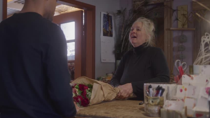 A florists sells a customer a bouquet of flowers