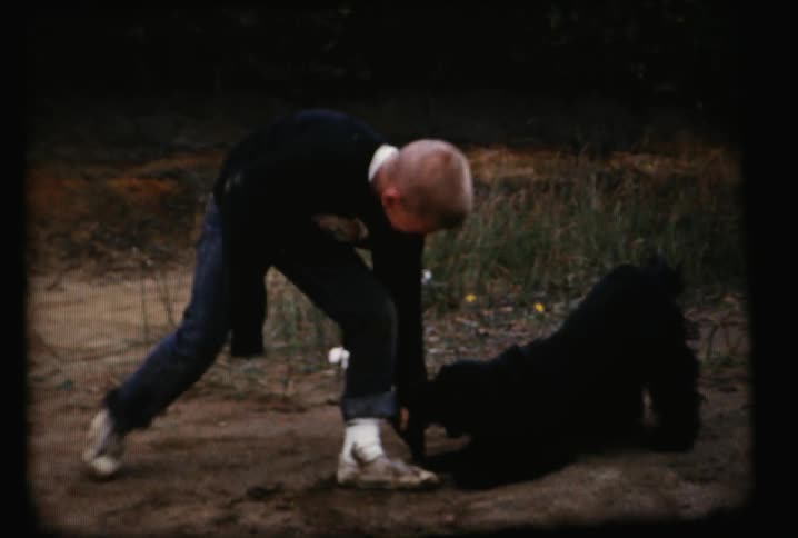 A boy is running playing with a dog