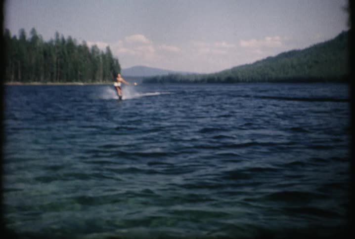 A man skiing on a waterway with a white float around his waist