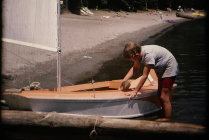 A boy is cleaning a small boat
