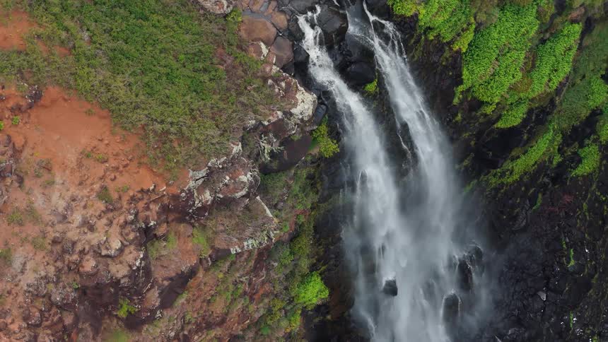The waterfall crashes over the steep cliff