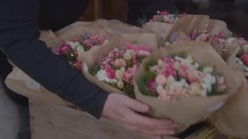 The florist arranges bouquets in a crate