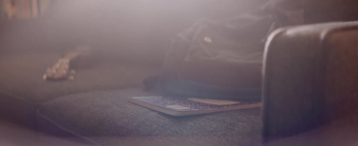 A guitar and bag are on the couch