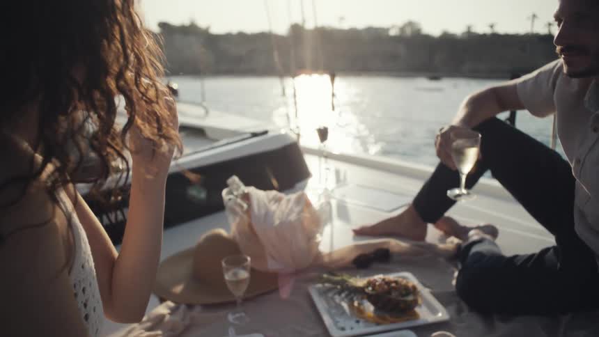 Woman and man toasting during a picnic on a boat