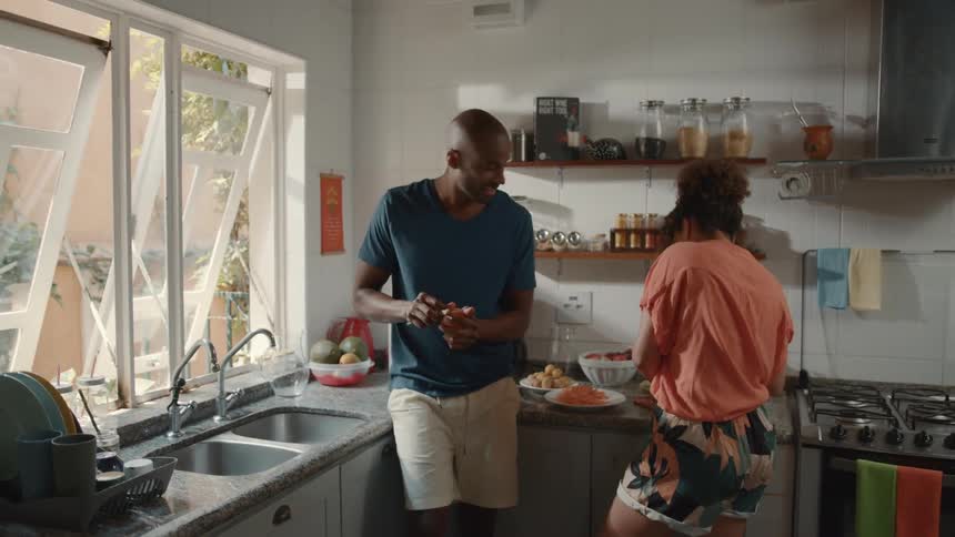 A man and woman talk while cooking
