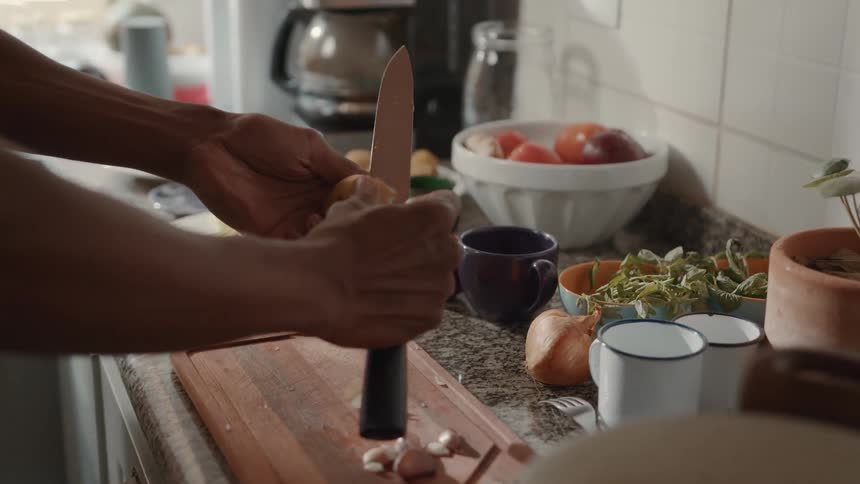 A man is cutting vegetables in the kitchen