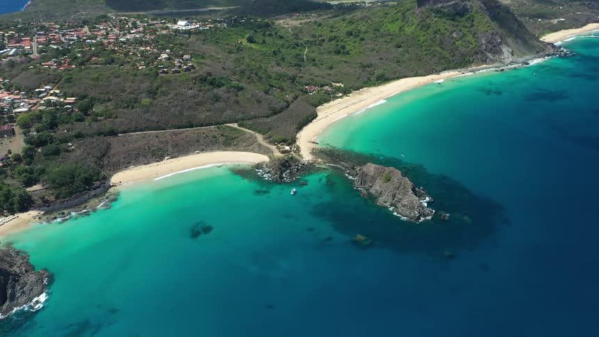 Aerial landscape of a turquoise blue island with an urban city in the background