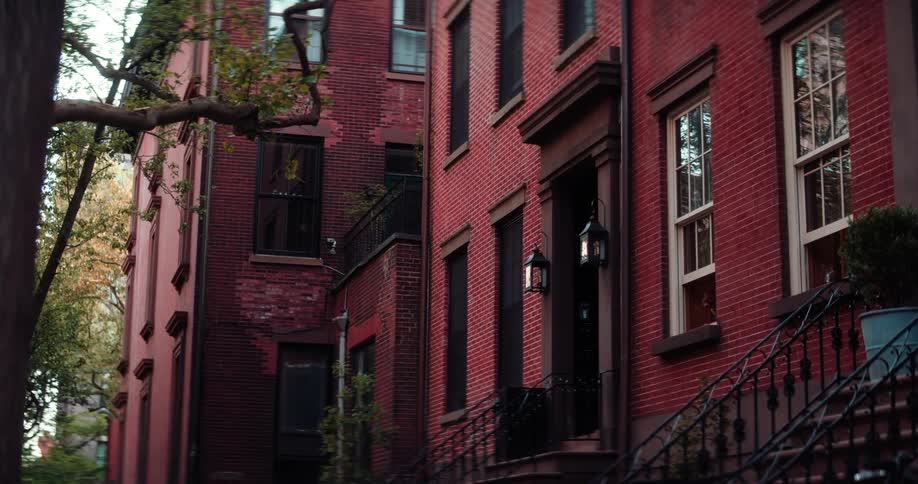 A shot of the exterior of a classic brick townhouse with a detailed front stoop and railings showcasing the buildings architecture