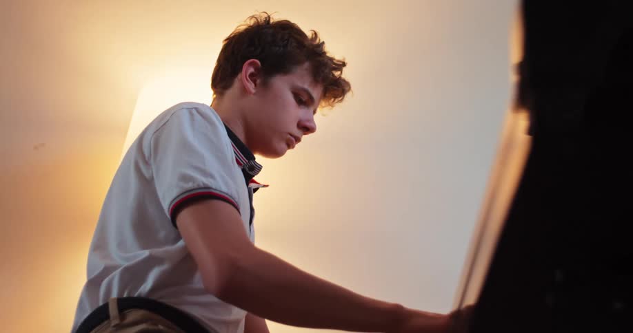 Concentrated teenager playing piano