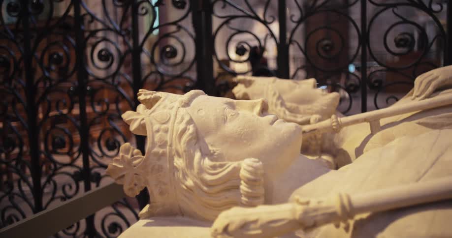 Two white plaster statues inside a cathedral