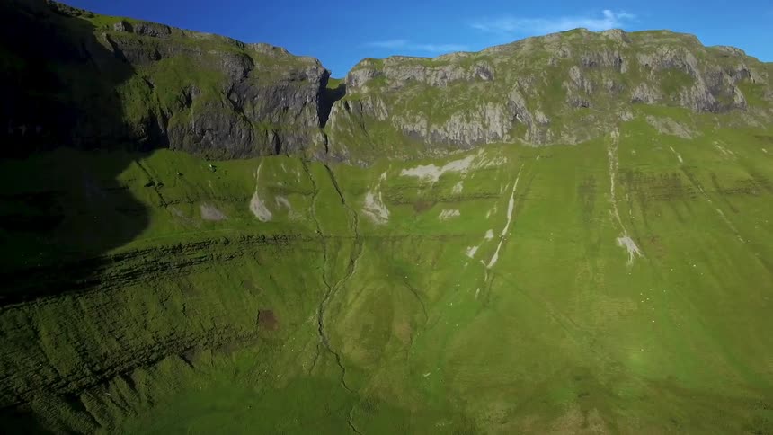 Green grass and moss grows on the hillside