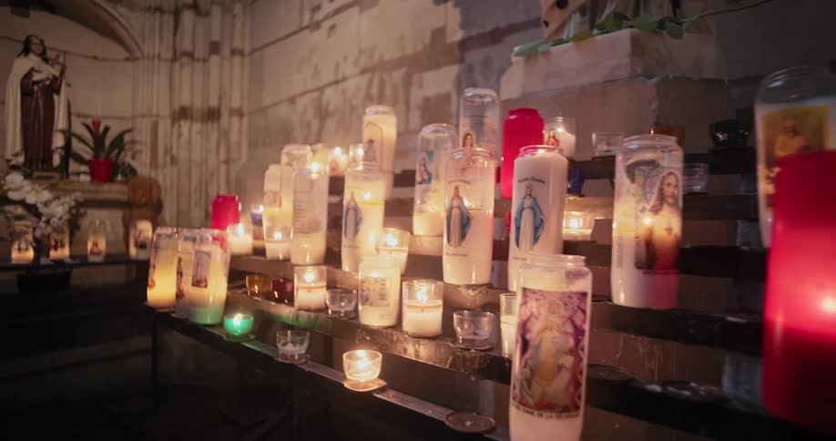 Small candles are lit as a votive offering during christian prayer in catholic churches