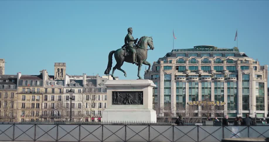 Square with a bronze statue and buildings in the background