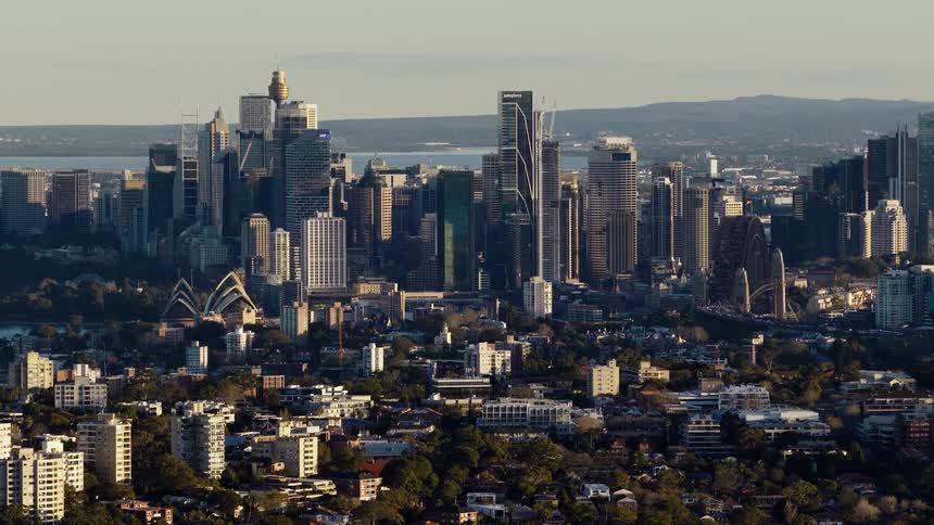 Aerial panorama of a metropolis with modern skyscrapers and the sea and mountains in the background