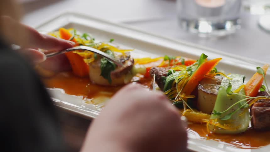 A person is eating food from a plate