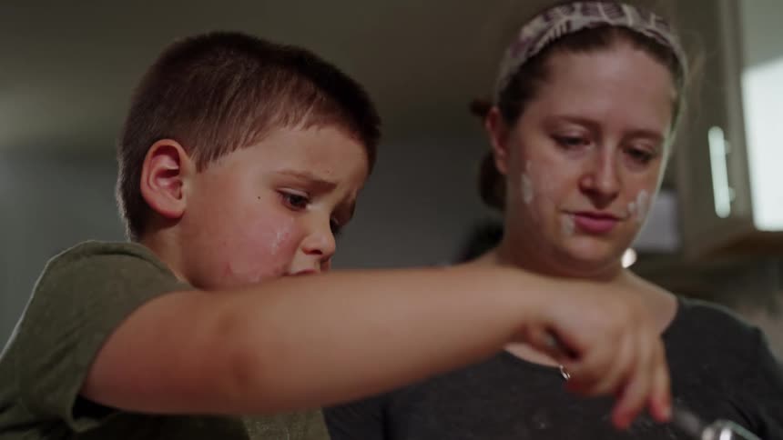 Boy baking with mother in the kitchen