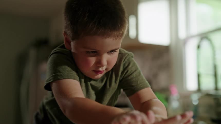 Boy rolling dough in a kitchen