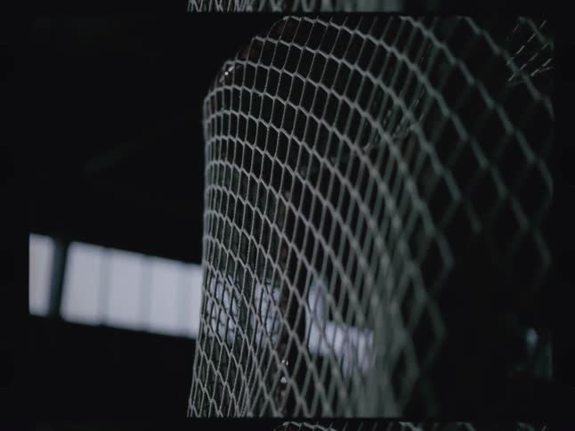 A puck slams into a hockey goalpost net indoors at midday