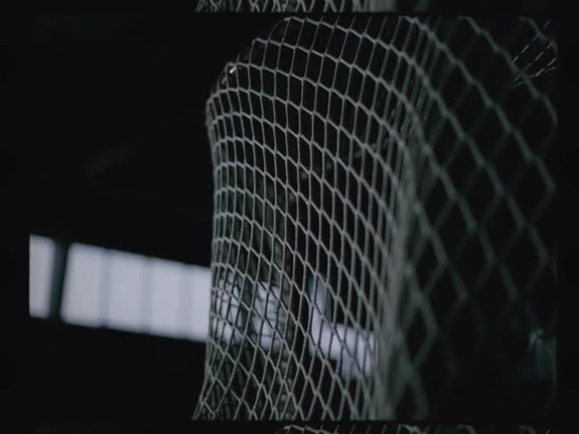 A puck slams into a hockey goalpost net indoors at midday