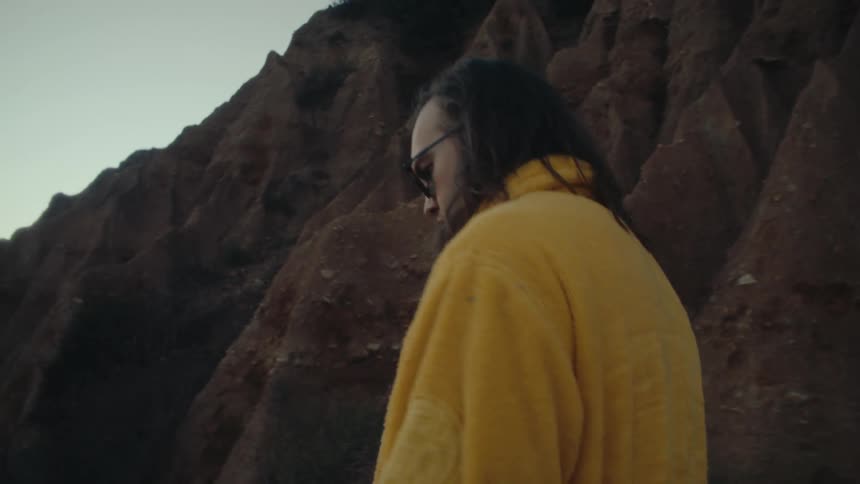 Man in sunglasses walking in natural surroundings at dawn