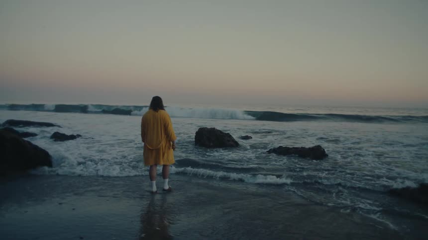 Man in yellow robe entering the sea