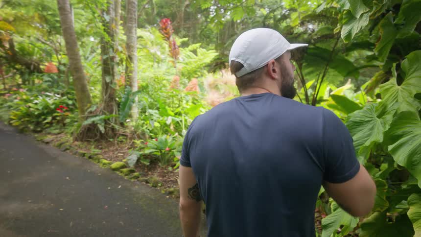 Man with a white cap walking along a trail in a natural park