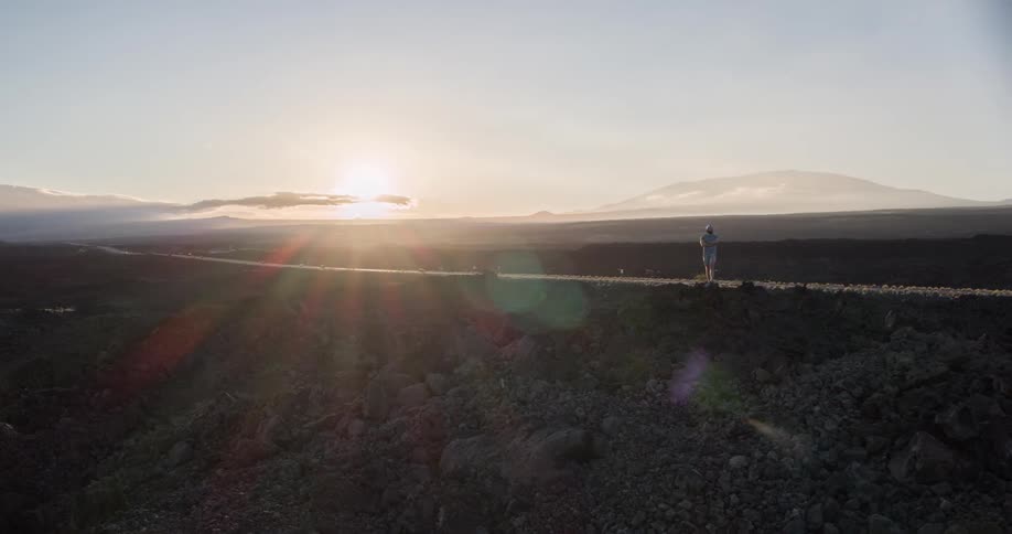 A man stands atop a mountain
