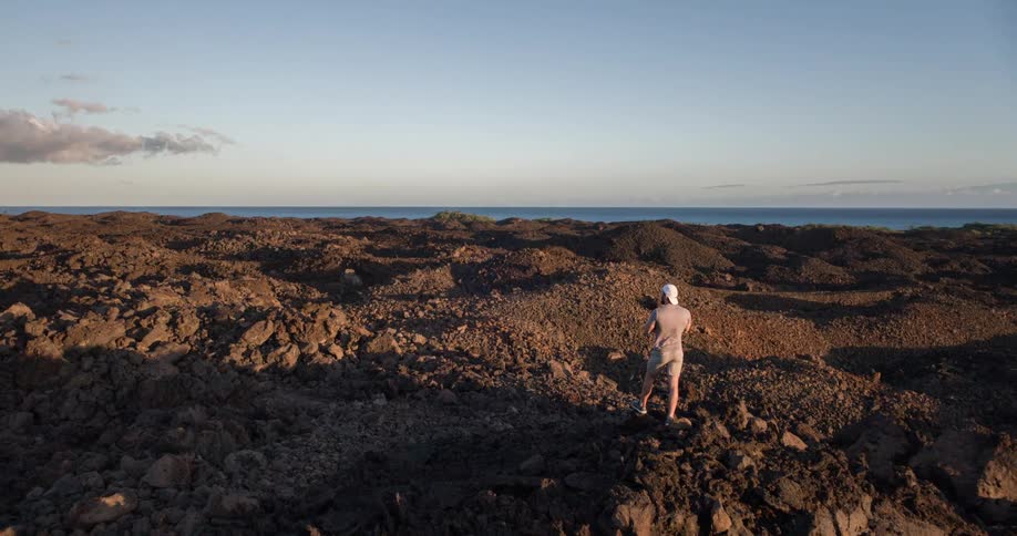 Man in a rocky environment with the sea landscape in the background