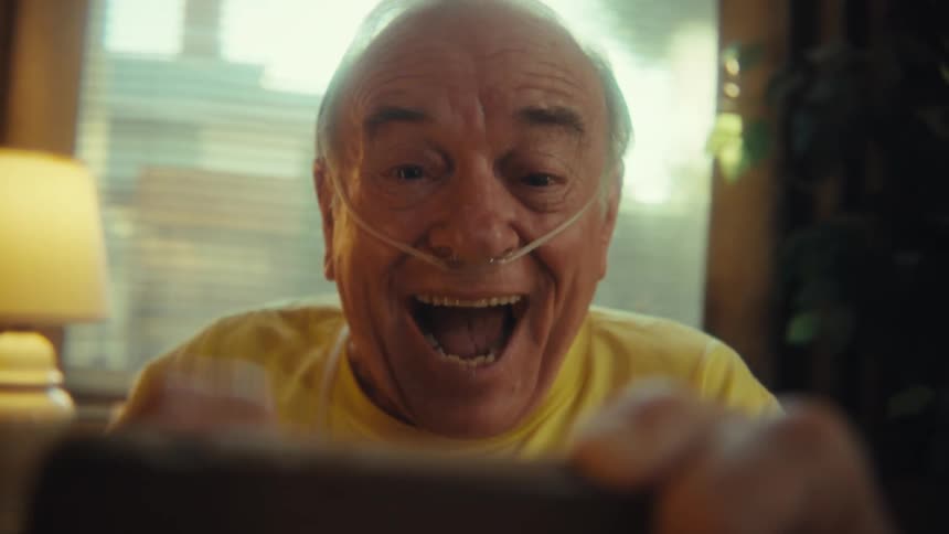 A man is cheering at his cell phone