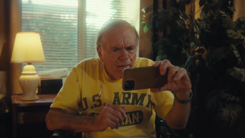 The man looks at his phone at home