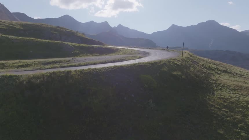 A cyclist riding along a curved road