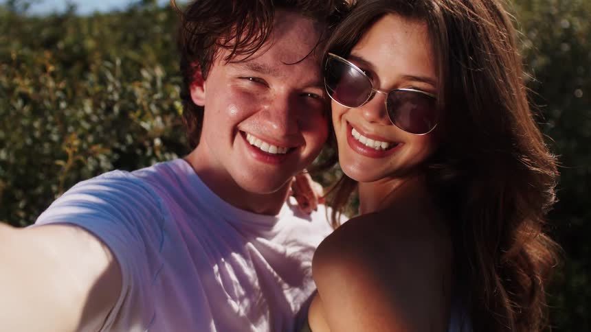 Couple smiling for a selfie outdoors