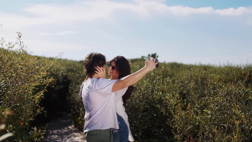 Couple in a field taking a photo