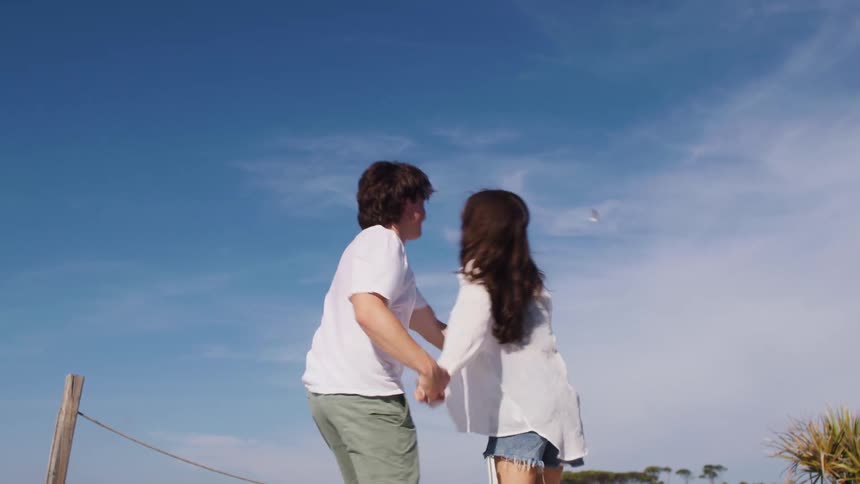 Couple holding hands running and hugging outdoors