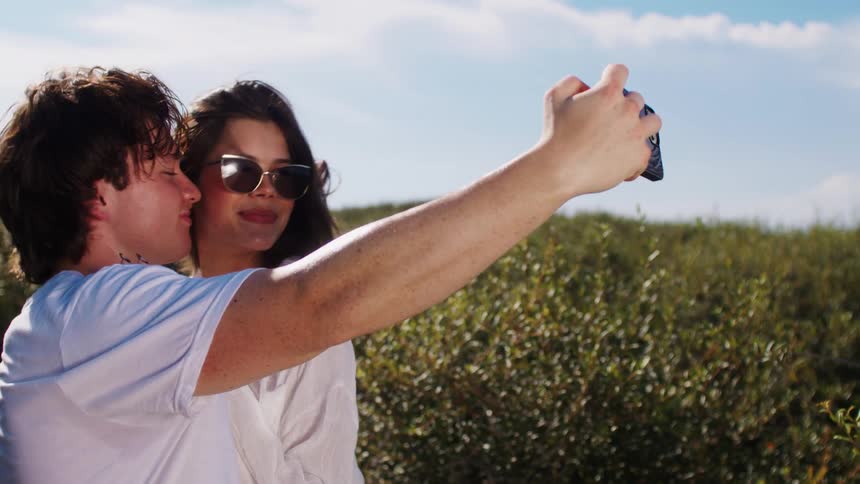 Couple smiling while taking a selfie outdoors