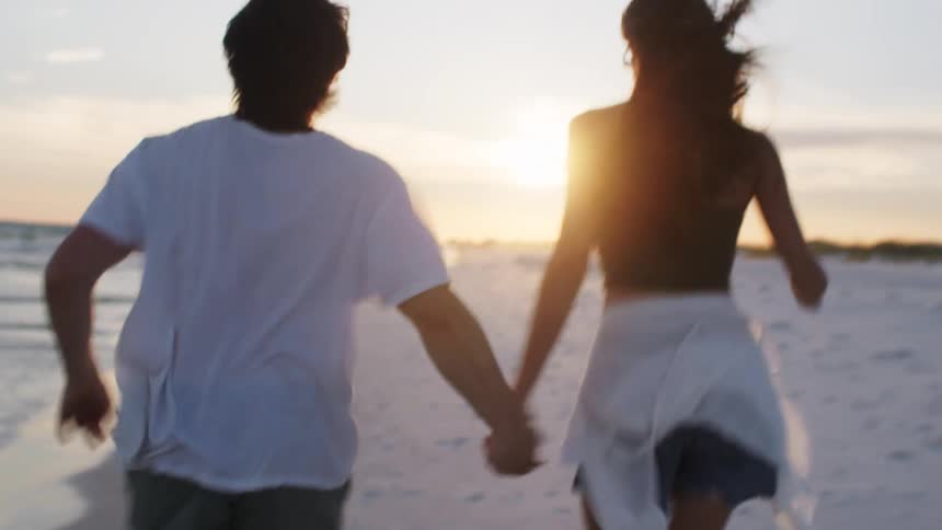 The man and woman run on the beach