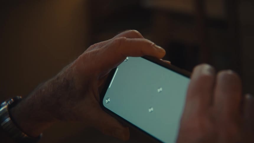 Man holds his phone with a green screen and circles in the corners