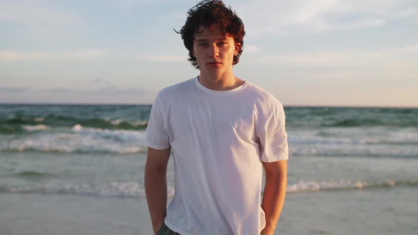A boy stands at the beach
