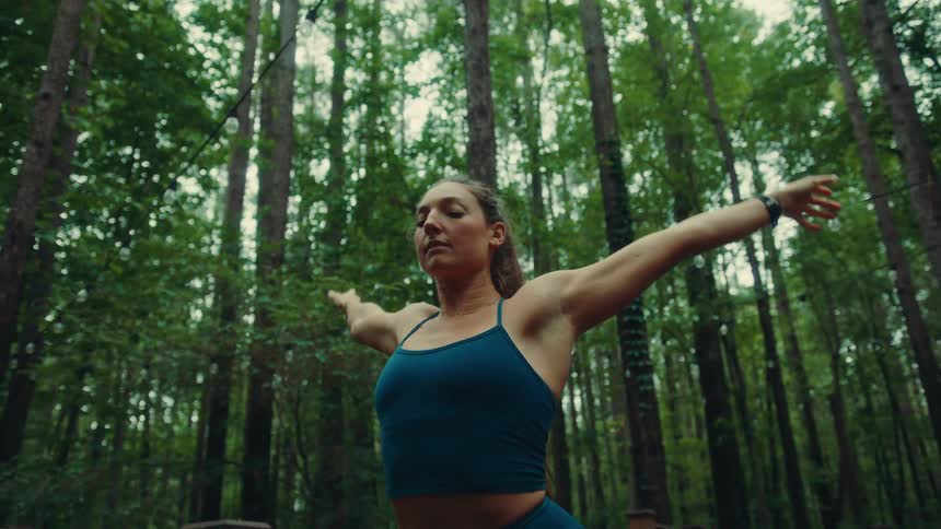 A woman is stretching and doing yoga by the forest