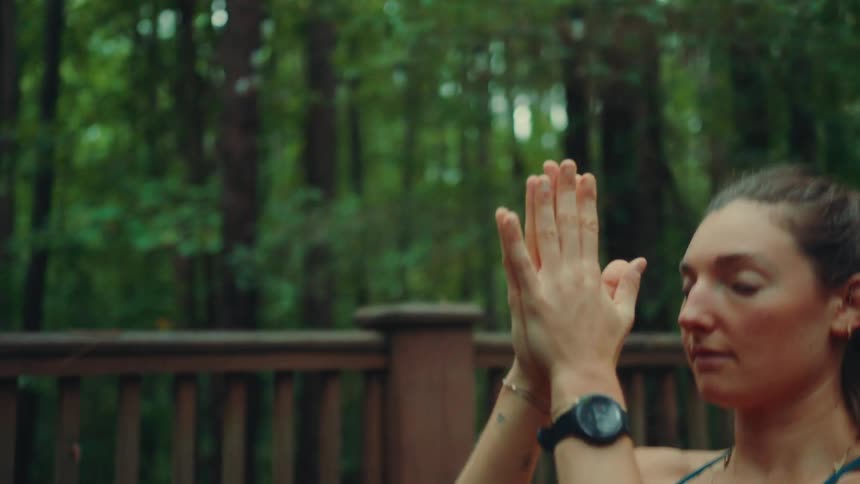 Woman practicing yoga outdoors with arms raised