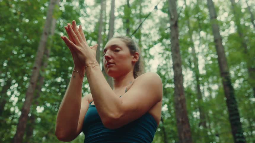Concentrated woman doing yoga exercise in the forest