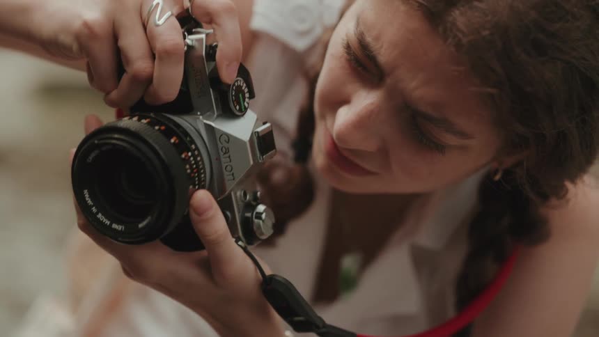 A woman focuses her camera