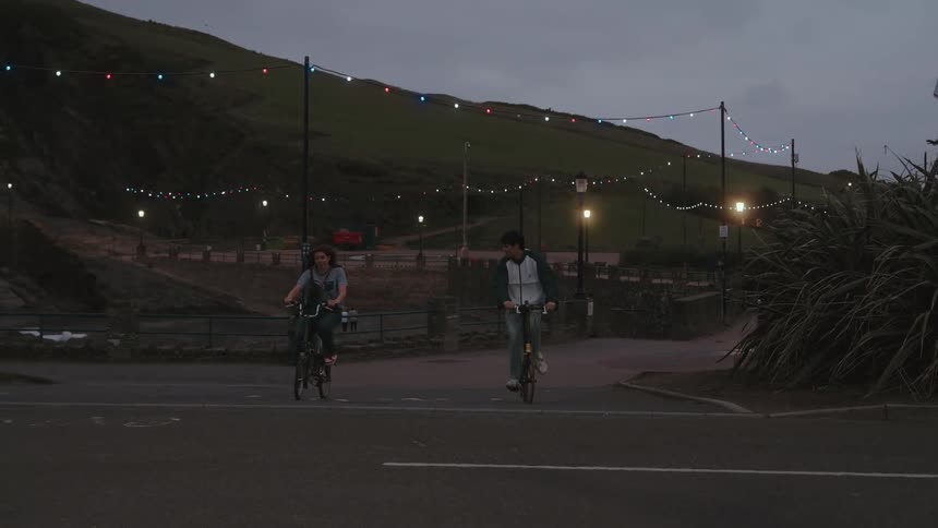Man and a woman riding a bicycle in the late afternoon