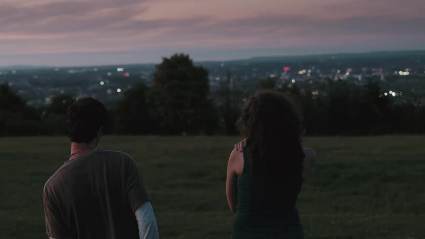 Two people watching the city lights at dusk