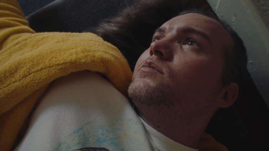 Man lying down with a thoughtful expression