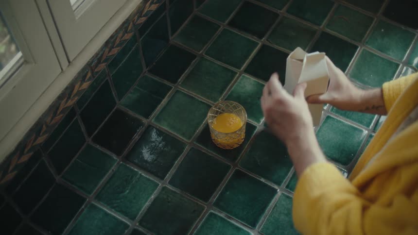 A person pouring a cup of juice