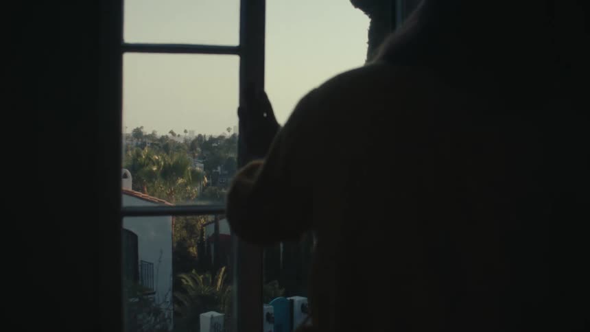 Person closing the window in the late afternoon