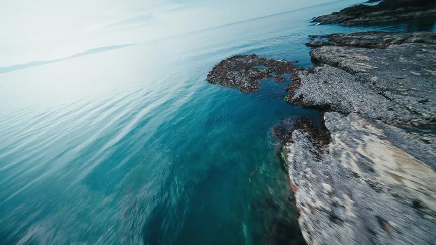 The island is lined with rocks and trees