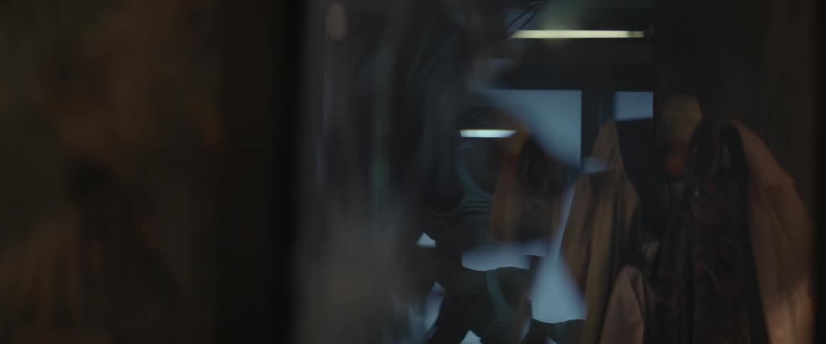 A cracked mirror reflects a man hitting something