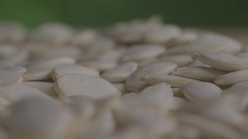 Closeup of white pumpkin seeds spread on a surface